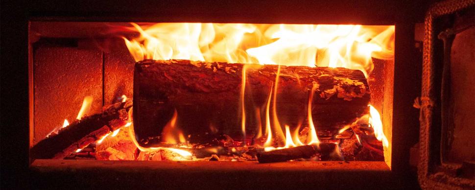 A log burning in wood fire stove.