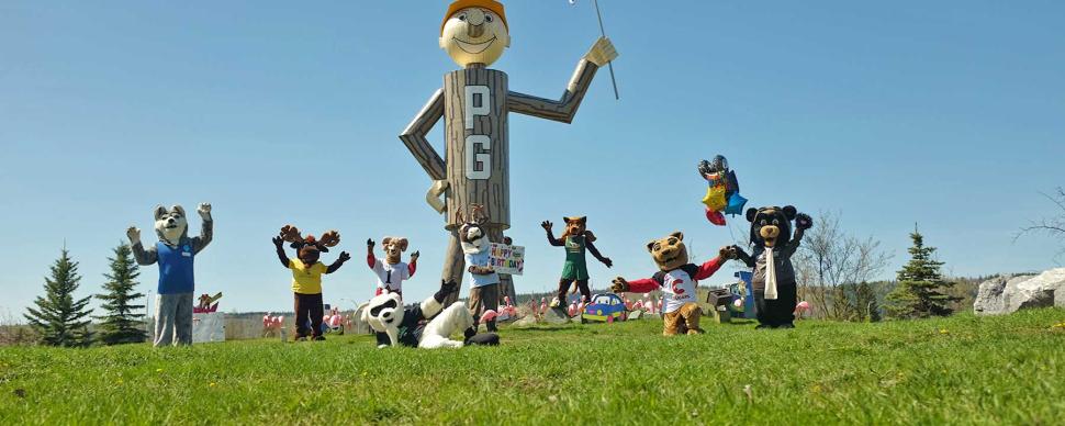Local costumed mascots celebrate Mr. PG's birthday by posing with his statue.