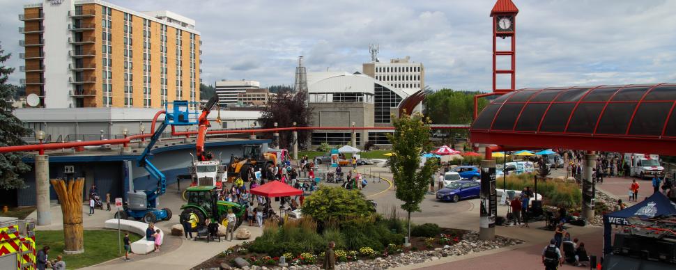 Crowd and variety of trucks at Canada Games Plaza on a cloudy summer day.