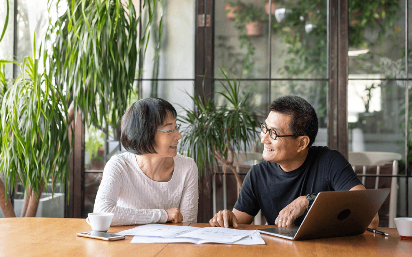 Two people sitting at a table and smiling as they look at each other