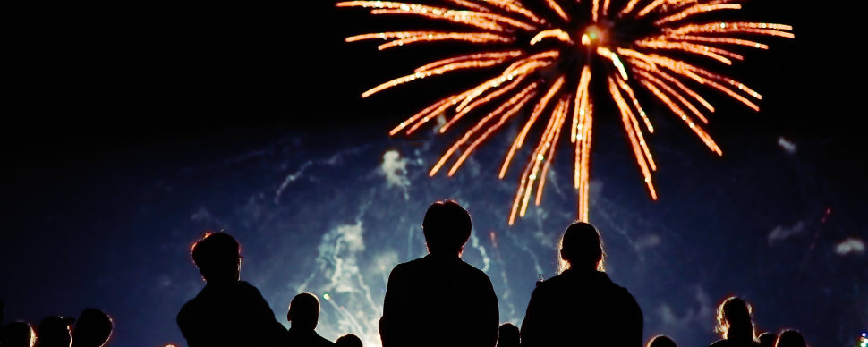 Silhouette of crowd watching fireworks at night